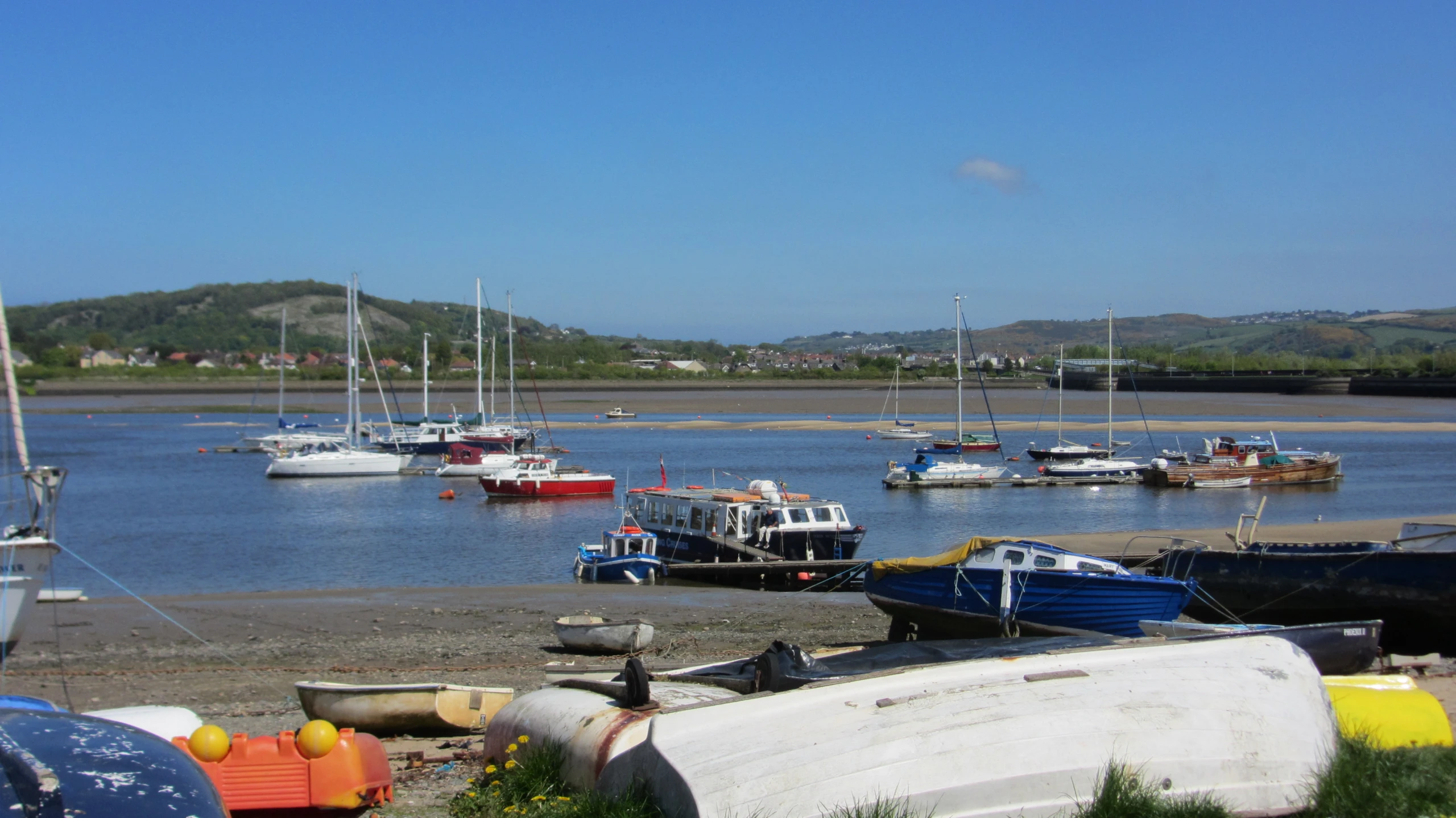 many boats docked on the shoreline in a large harbor