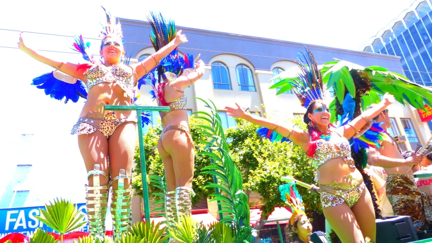 two woman in body suits standing on some pole in a parade