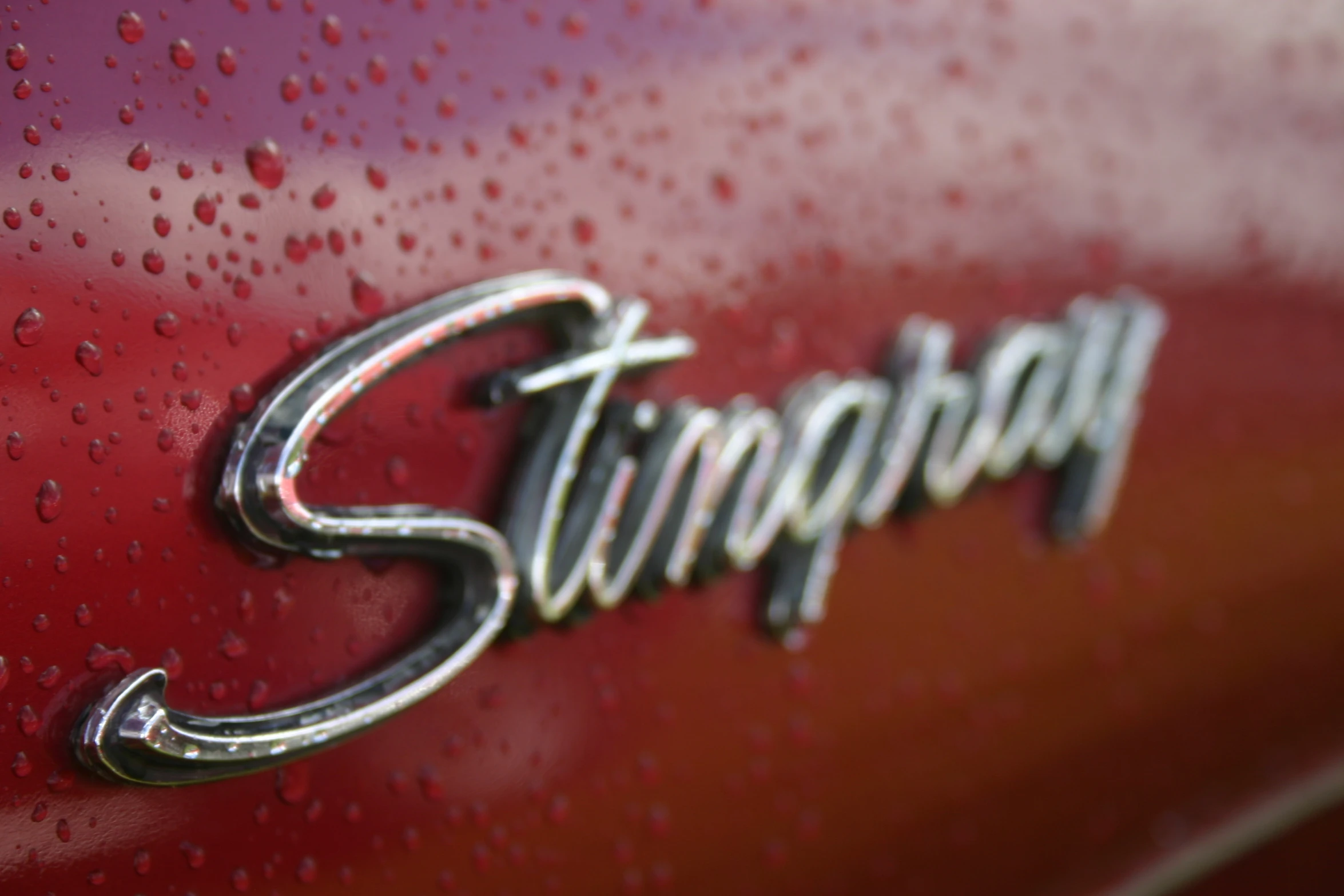 the name shipman on a red car is covered in rain drops