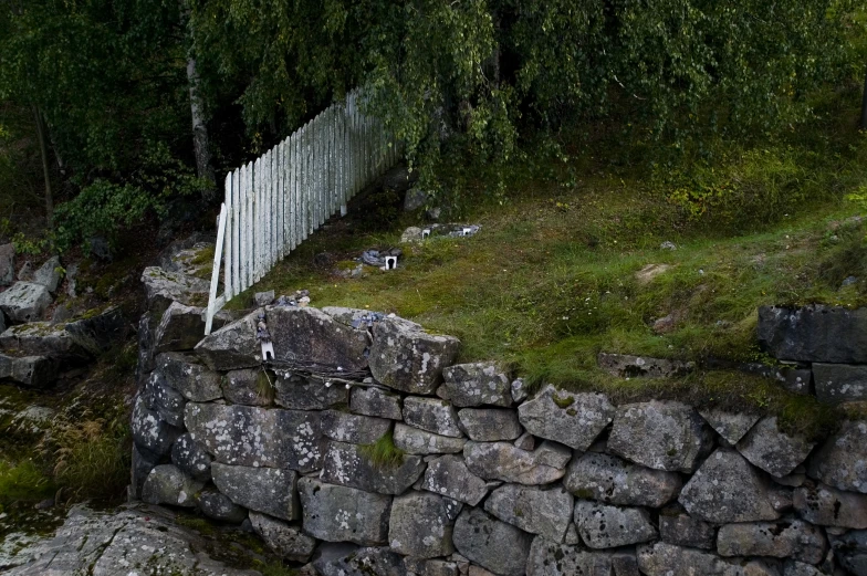 stone fence, rock and a row of white chairs and trees