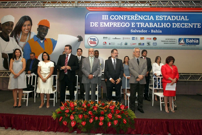 people standing on chairs with two flags and one sign in the background