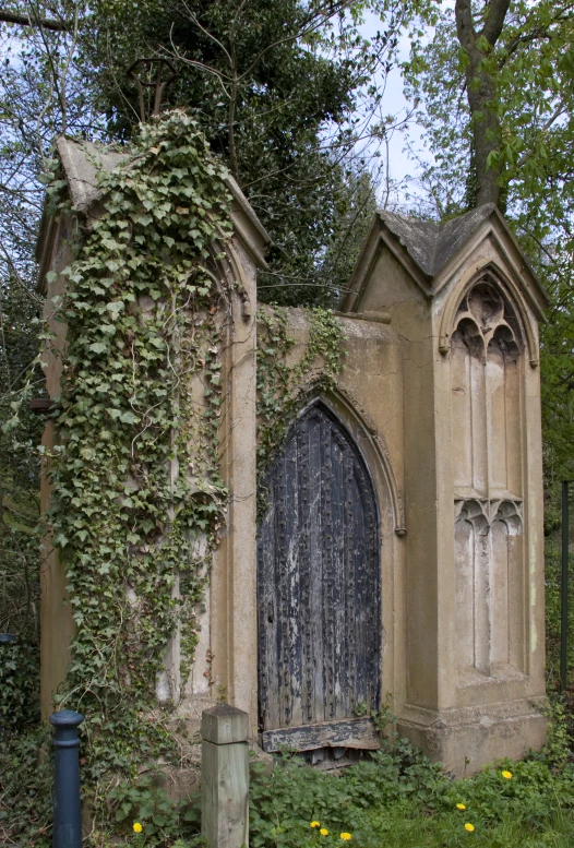 a stone building covered in ivy by a fence