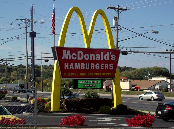 the sign for mcdonald's hamburgers is on the side of the road