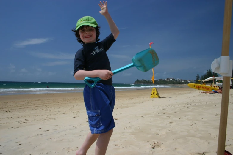 the little boy is smiling holding a shovel