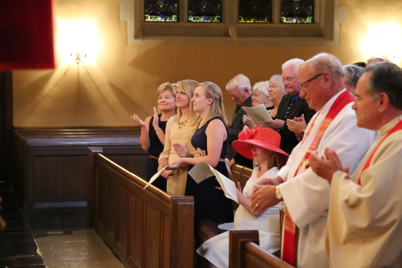 many people in a church standing and clapping together