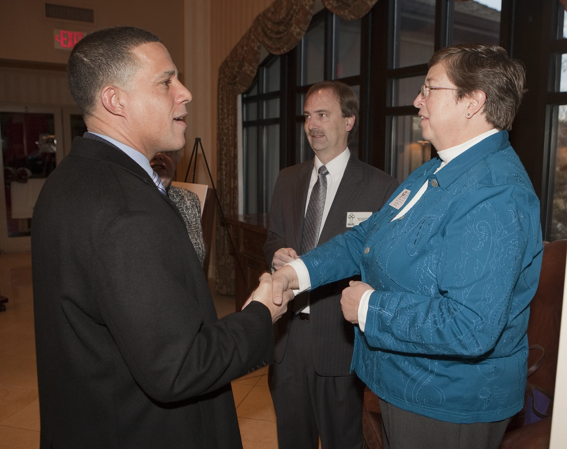 two men dressed in suits and ties talking to each other