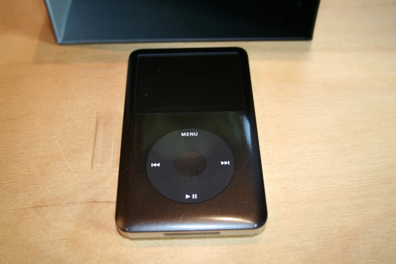 an ipod sitting on a table next to a laptop