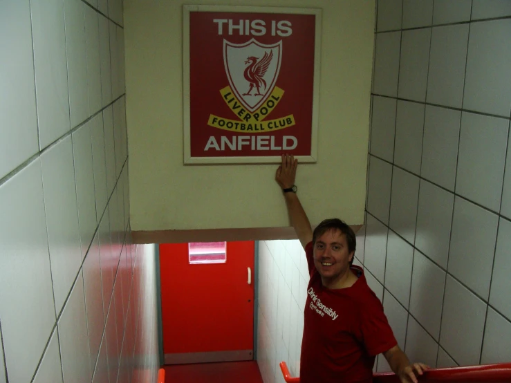 the young man smiles as he walks up the hall