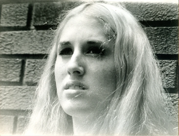 a young blonde woman with long hair and wearing long lashes