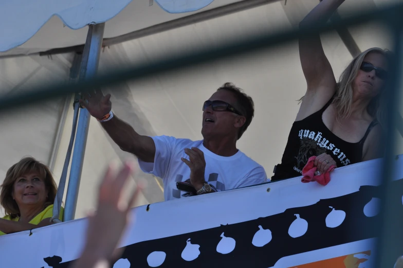 the people are waving and posing on a stage