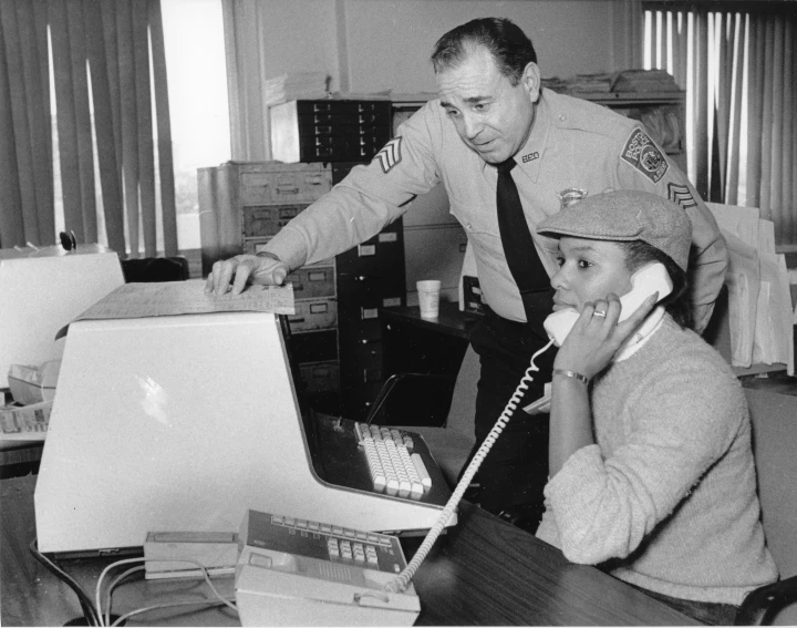 two people with telephones in an office setting