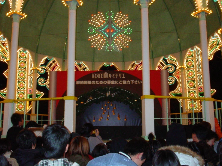 a crowd of people are watching a display on the ceiling