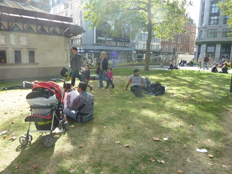 a group of people standing in a park near a grass area