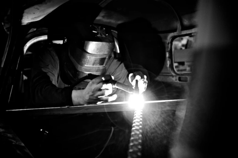 welder doing welding to the metal part in the car