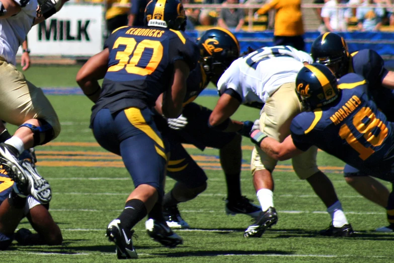 two football teams playing a game, one is holding the ball