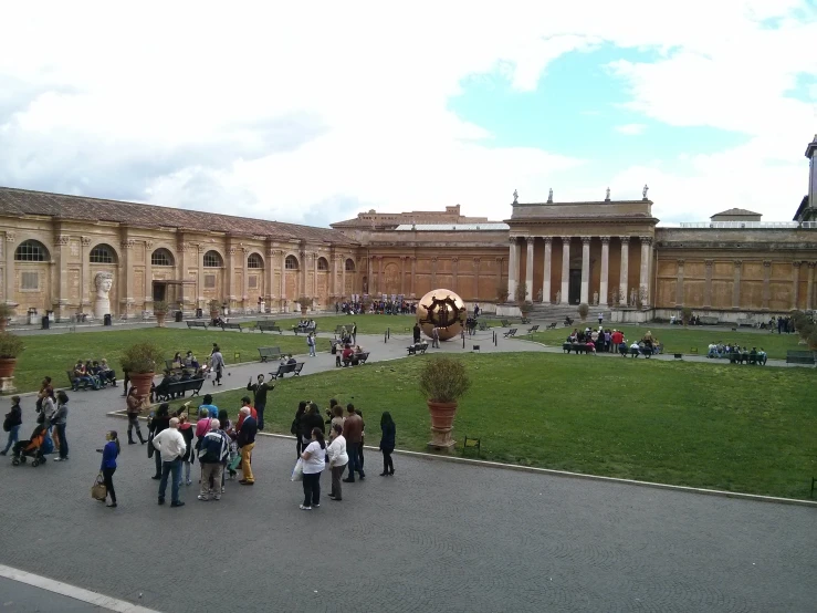 a group of people walking on a paved pathway with many buildings in the background