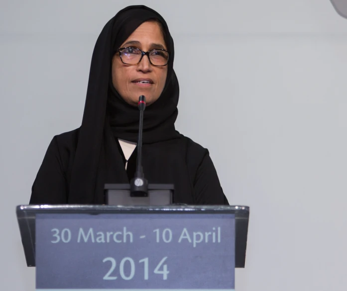 a woman in a veil at a podium