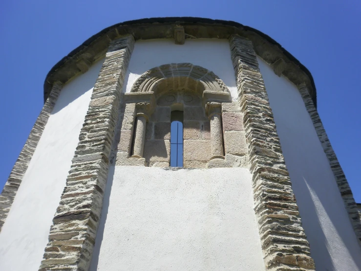 looking up at the top of a very tall tower with archways