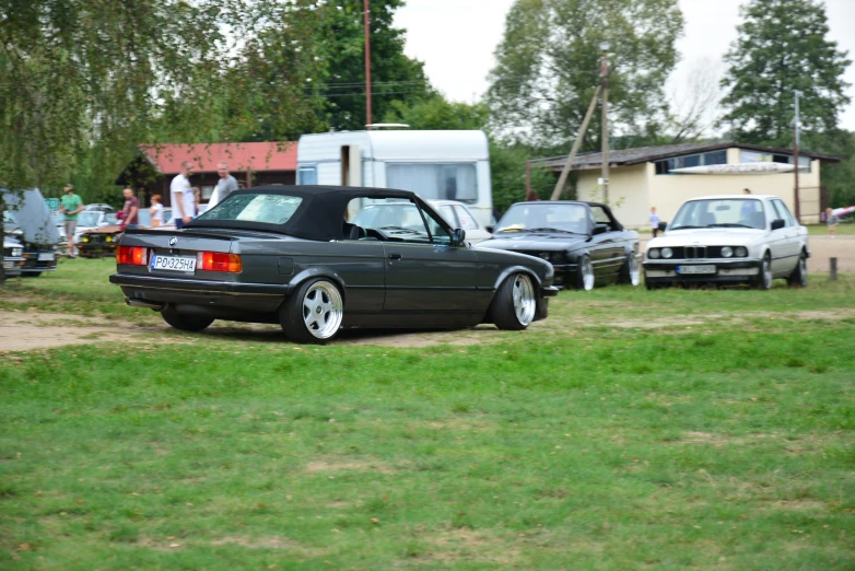 an older car sits parked in a field