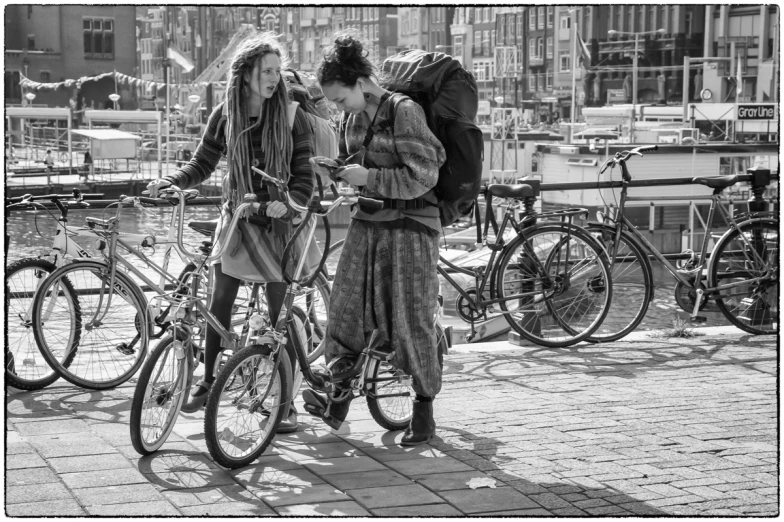 the black and white po shows two woman near their bicycles