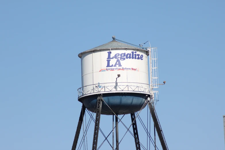 a water tower sitting in front of a blue sky