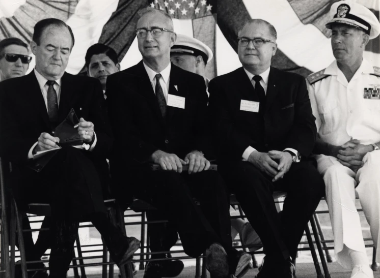 a group of men in suits are sitting next to each other