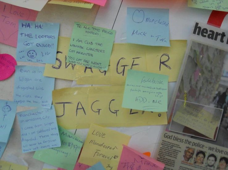 a wall covered with sticky notes and other paper work