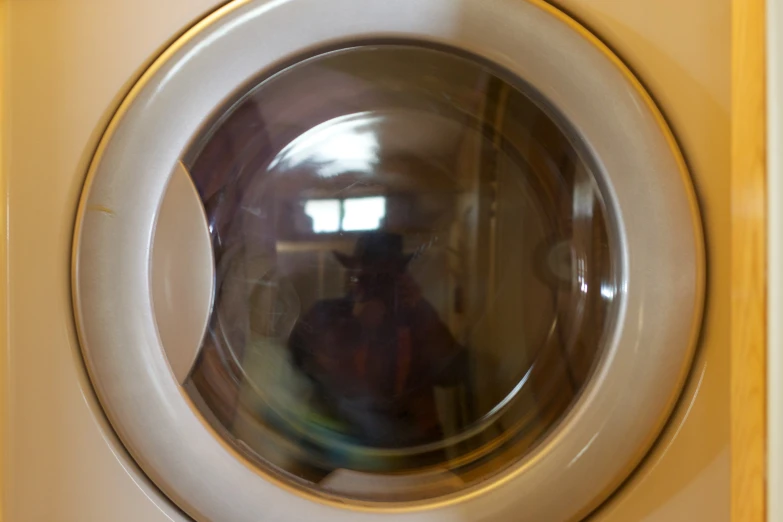 a dryer with the reflection of a person standing in it