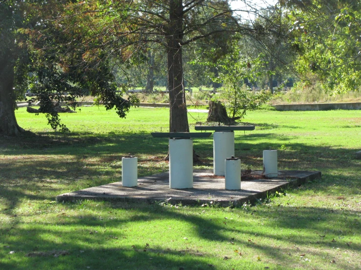 three water towers in a field by trees