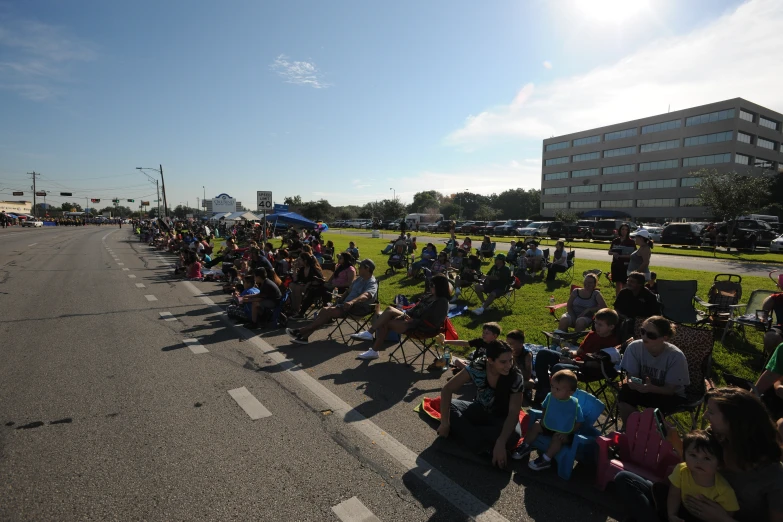 there are many people waiting on the side of the road