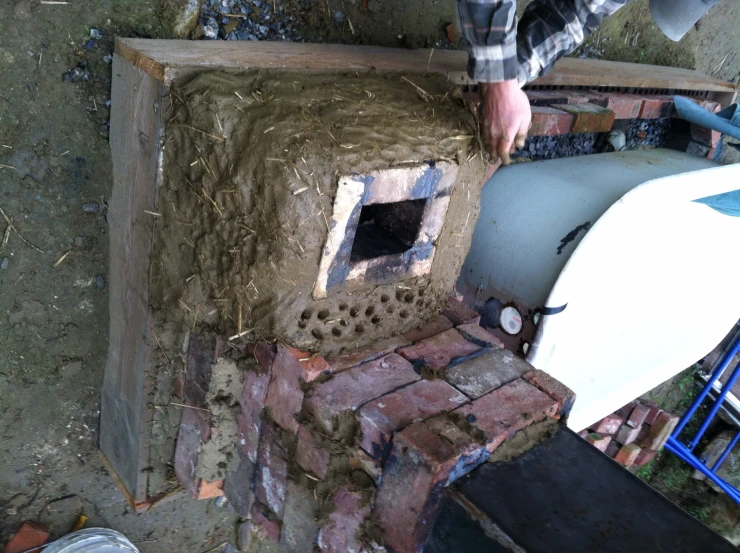 a white toilet sitting next to a brick oven