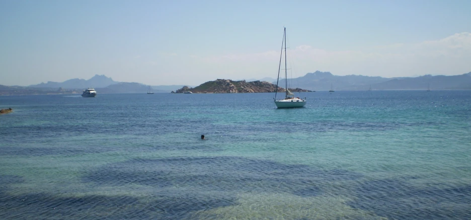 boats sailing in the sea at a rocky bay