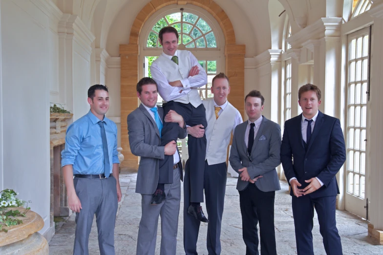 seven businessmen are posing for a po inside a formal building