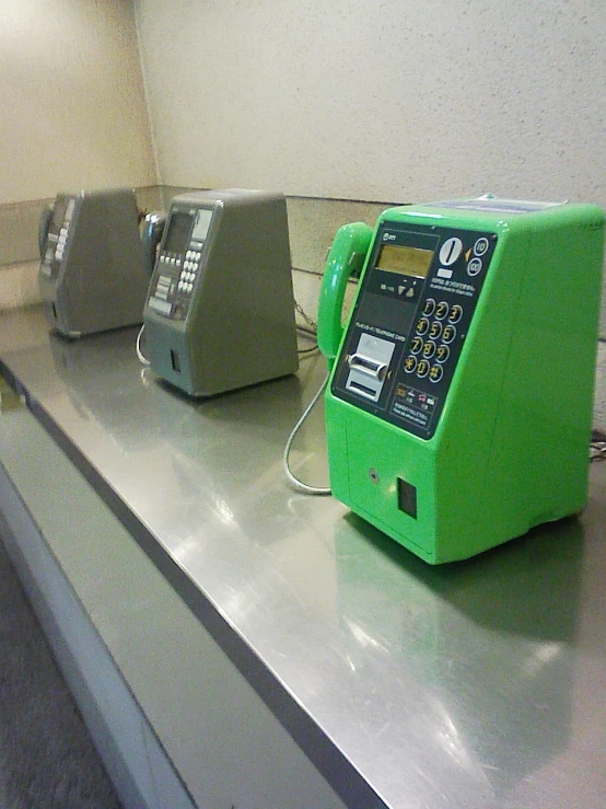 an electronic payment terminal sits atop the counter in a public restroom