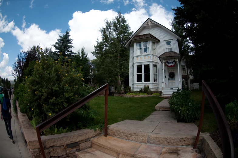 a large house with some stairs and a man walking down it