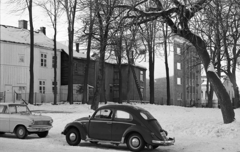 black and white pograph of two old fashioned cars on snow