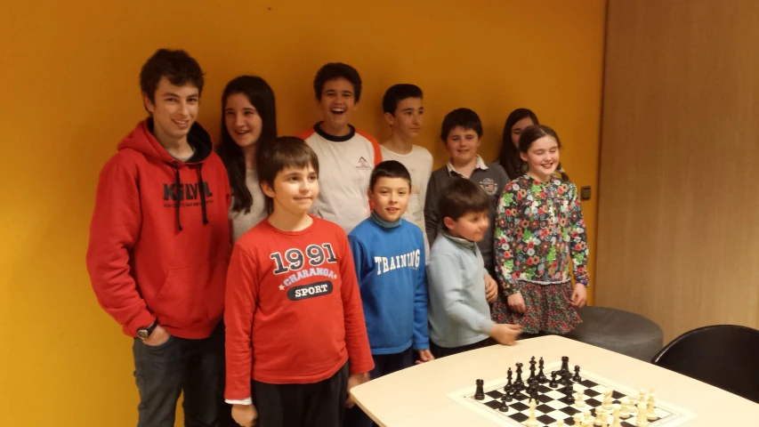 group of people standing behind chess board with table and chair