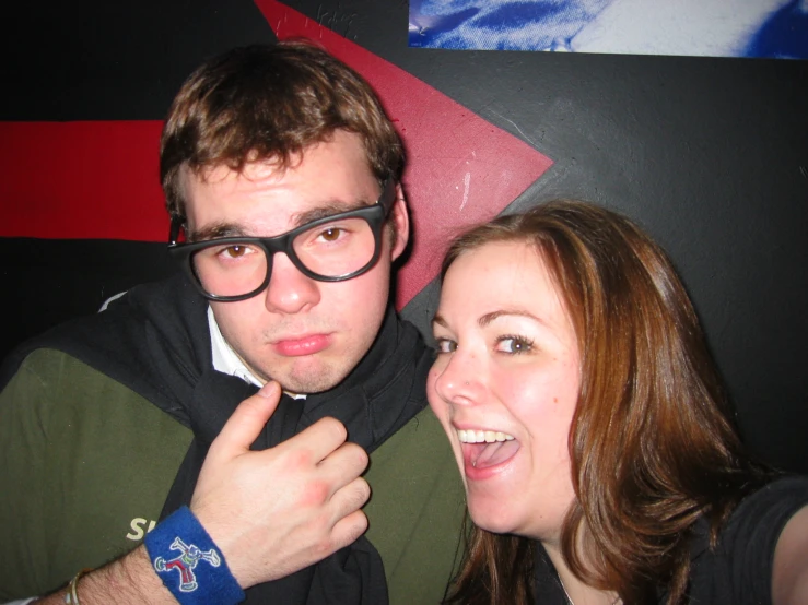 a man with glasses is posing next to a woman