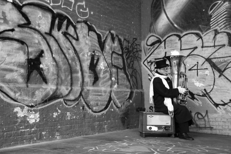 a person sits on a suitcase in a room with graffiti on the wall