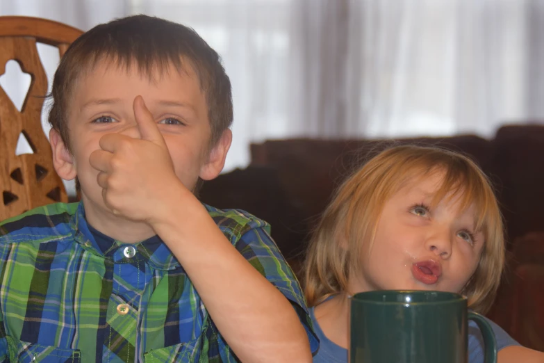 two young children are sitting in the chair with their mouths open