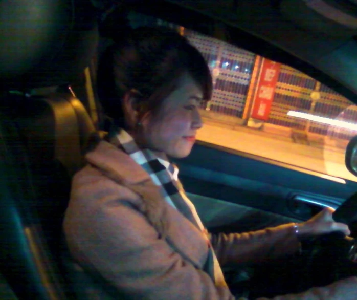 a woman sitting in a car with her phone up