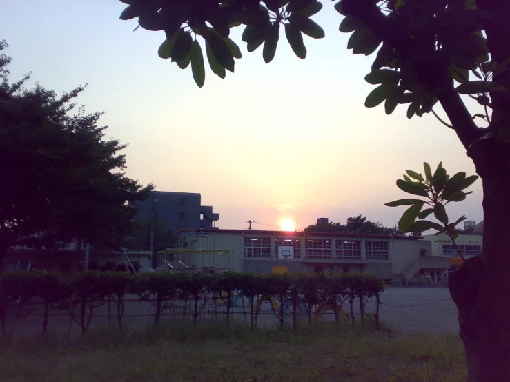 the sun is going down over some small buildings