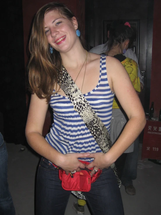 girl in a blue and white striped top standing with her belt undone