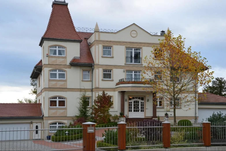 a large beige house on the corner of a residential street