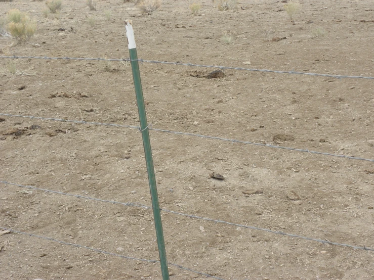 a picture of a fence that has a fence top and some wire on it