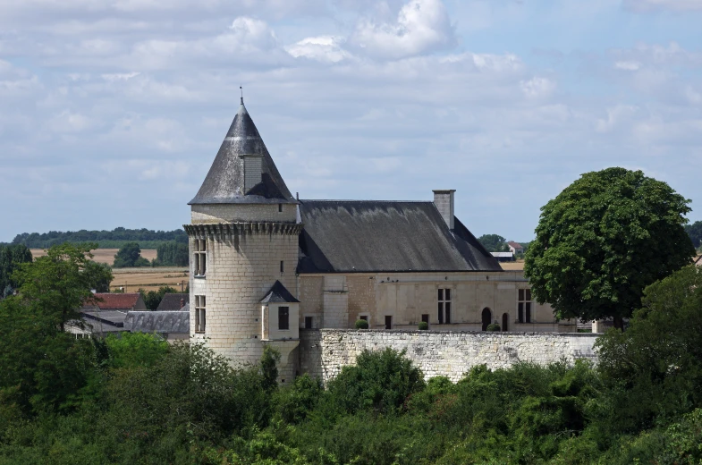 the building is a medieval castle with a pointy roof and pointed tower