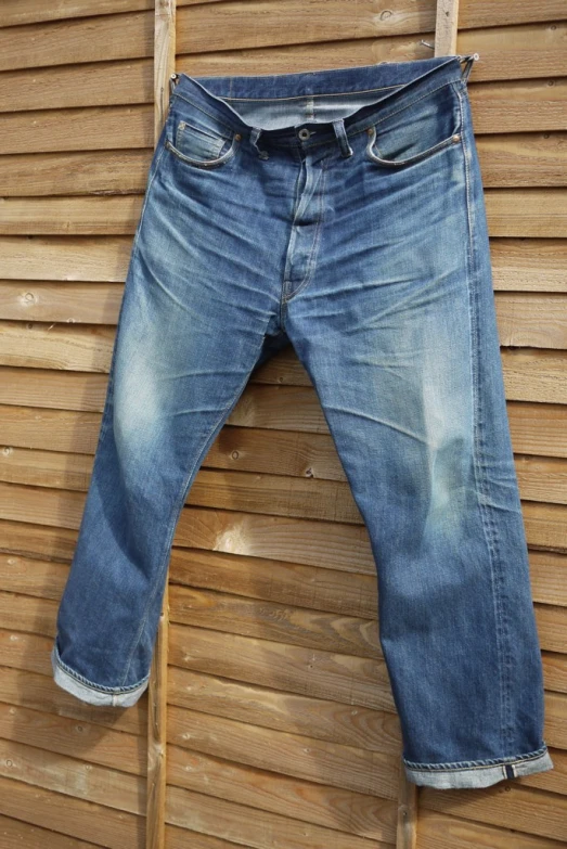 a pair of jeans on display on a wooden hanger