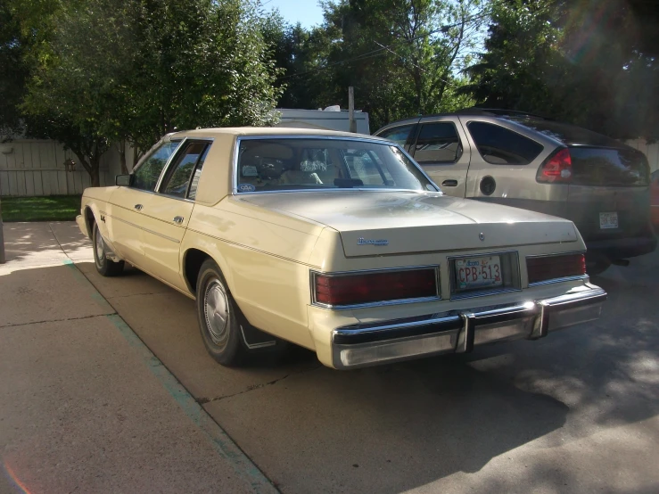 a car parked at a street corner near a bunch of trees