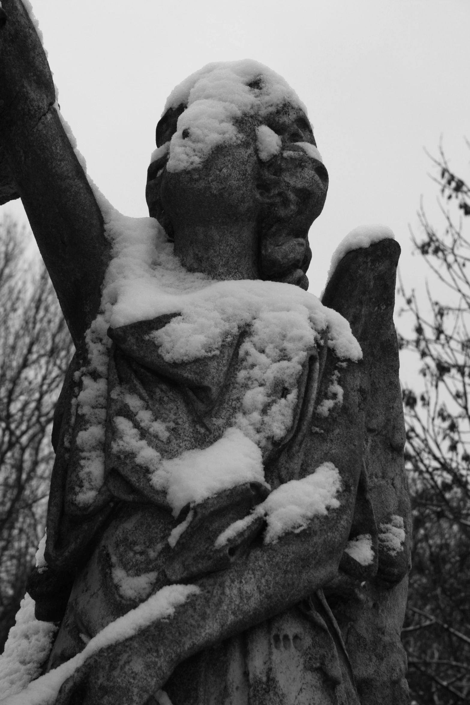 a statue is covered in snow with an angel on its back