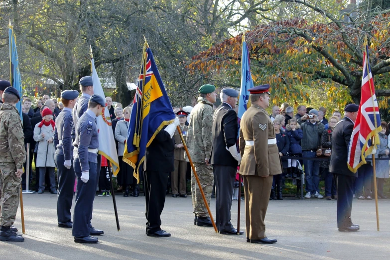 several people dressed in uniforms are standing and holding flags